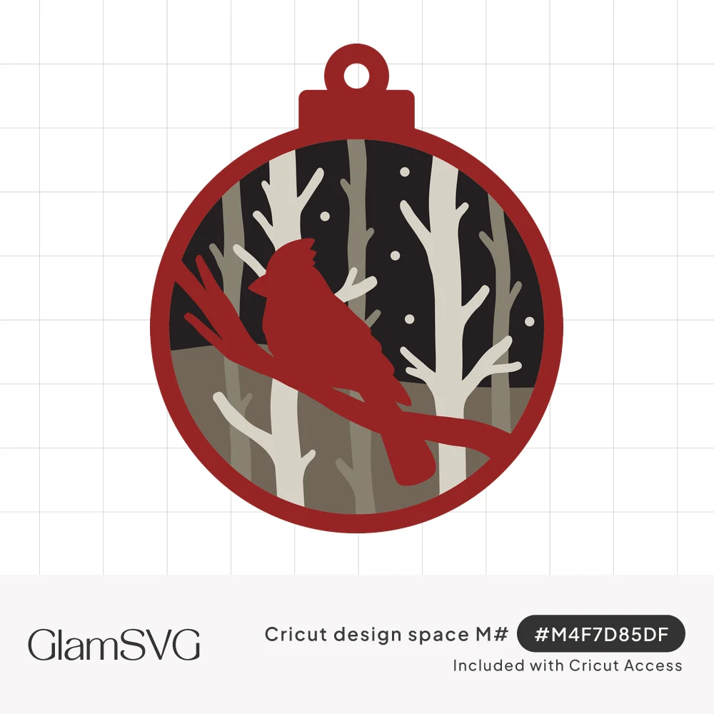 Layered round Christmas ornament with a red cardinal silhouette perched on a branch among white birch trees and falling snow