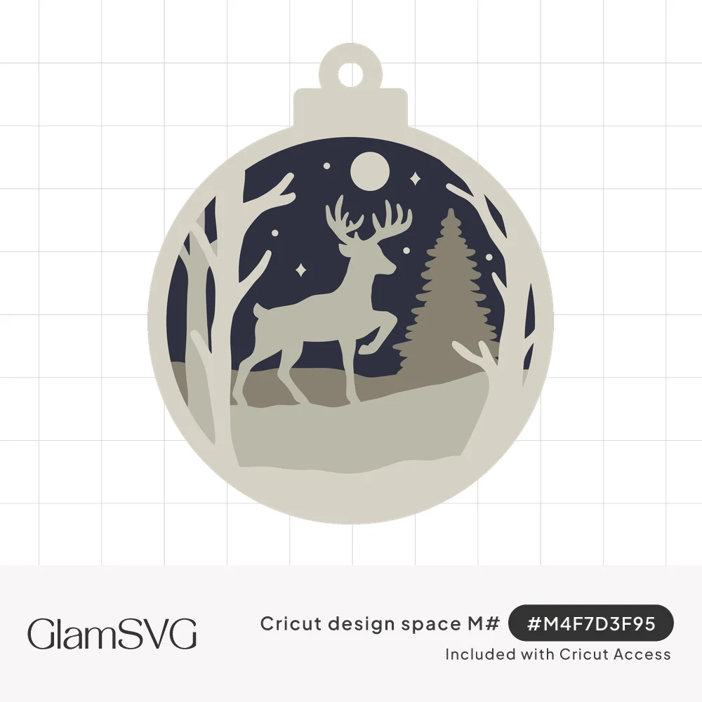 Round layered Christmas ornament showing a deer silhouette, pine tree and bare trees under a moon and stars in a night sky