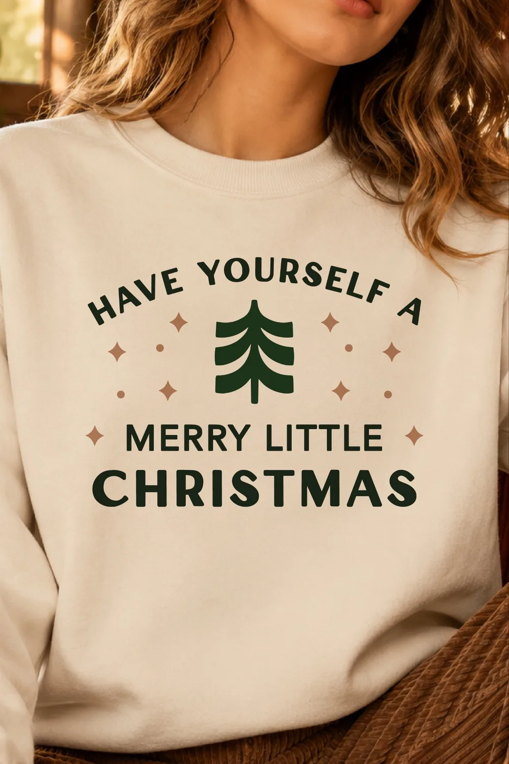 Cream sweatshirt on a woman with a green tree, tan sparkles and Have Yourself a Merry Little Christmas text