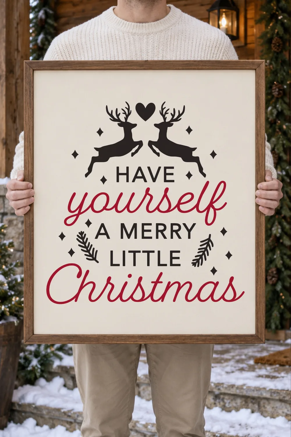 Wood-framed cream sign with leaping reindeer and Have Yourself a Merry Little Christmas, held on a snowy porch